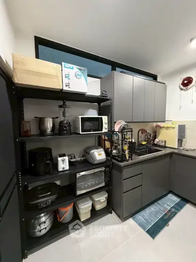 Modern kitchen with sleek cabinets and appliances, featuring ample storage and counter space.