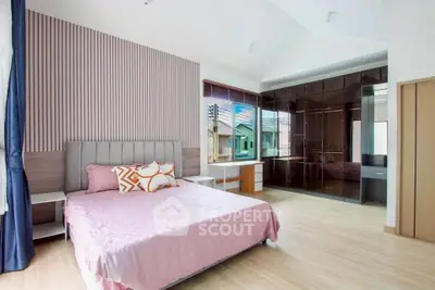 Spacious bedroom with modern design and large windows offering natural light.