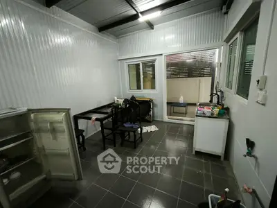 Spacious kitchen with open layout and modern design, featuring dining area and large windows.