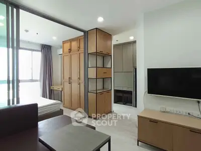 Modern studio apartment with sleek wooden furniture and sliding glass partition.