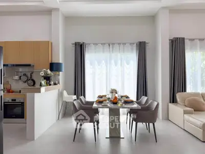 Modern dining area with elegant table and chairs, adjacent to a stylish kitchen and cozy living space.