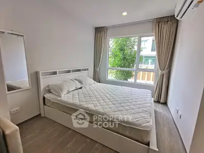 Bright and airy bedroom with large window and modern furnishings