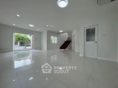 Spacious modern living room with glossy tile flooring and large windows