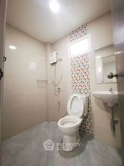 Modern bathroom with geometric tile accent and compact design