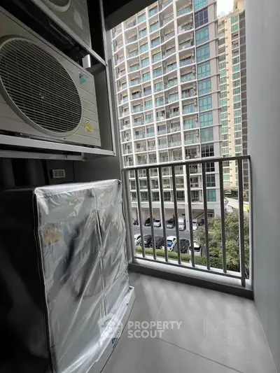 Modern balcony with city view and air conditioning unit in high-rise building.
