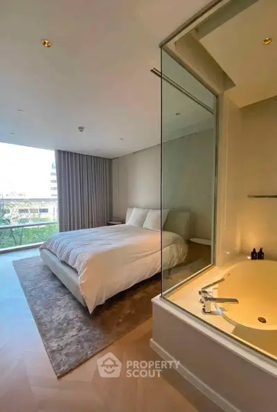 Luxurious bedroom with modern bathtub and large window offering stunning views.