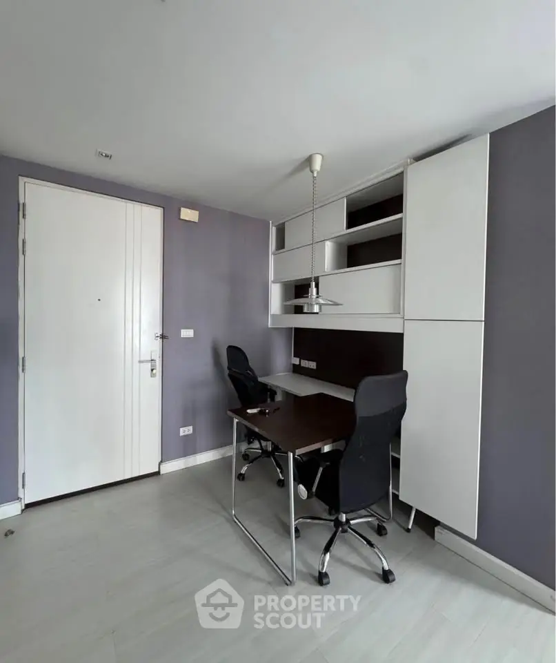 Modern study room with sleek desk and chairs, built-in storage, and stylish lighting.