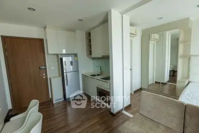 Modern compact apartment with open kitchen and cozy living area, featuring sleek design and ample natural light.
