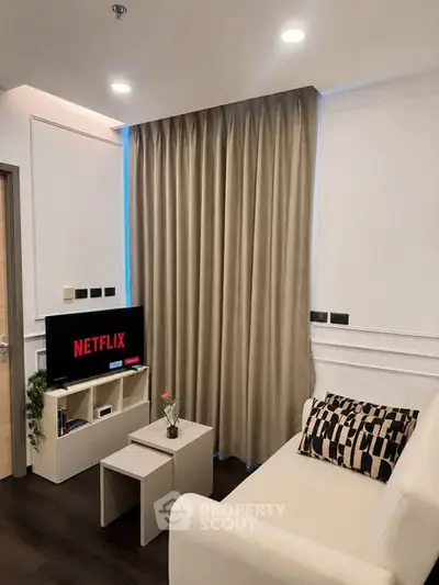 Modern living room with cozy sofa and TV, perfect for relaxation and entertainment.