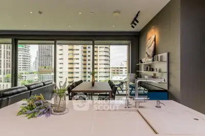 Chic urban apartment with open-plan layout featuring a sleek kitchen, spacious dining area, and a cozy living space with cityscape views through large windows.