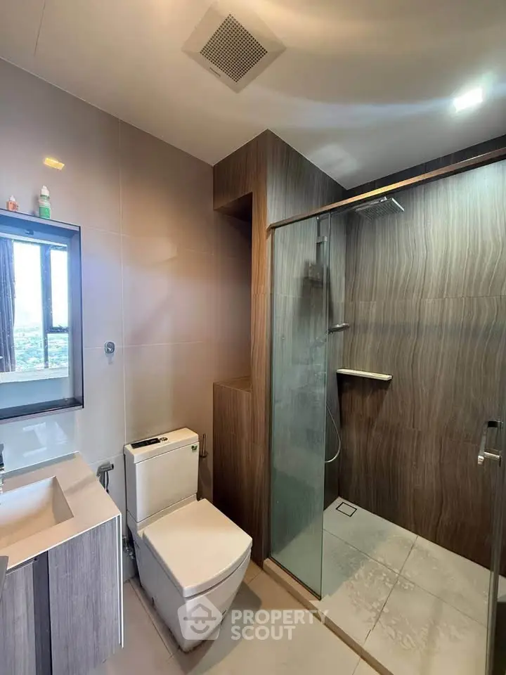 Modern bathroom with glass shower and sleek fixtures in a contemporary apartment.