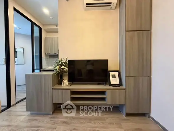 Modern living room with sleek wooden furniture and mounted TV, perfect for cozy relaxation.