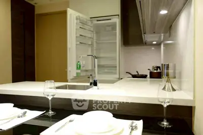 Modern kitchen with open fridge and elegant dining setup