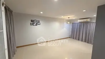 Spacious empty living room with modern lighting and large windows.