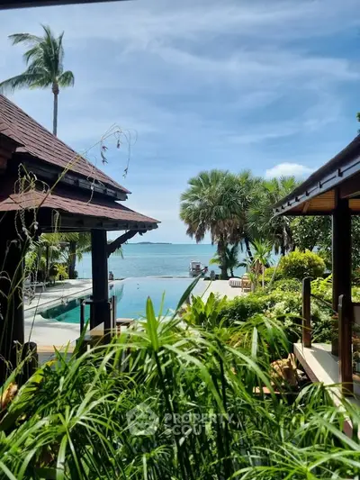 Luxurious tropical villa with stunning ocean view and lush garden, featuring a serene poolside setting.