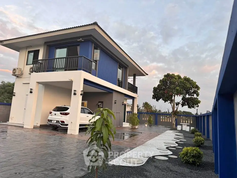 Modern two-story blue house with spacious driveway and landscaped garden