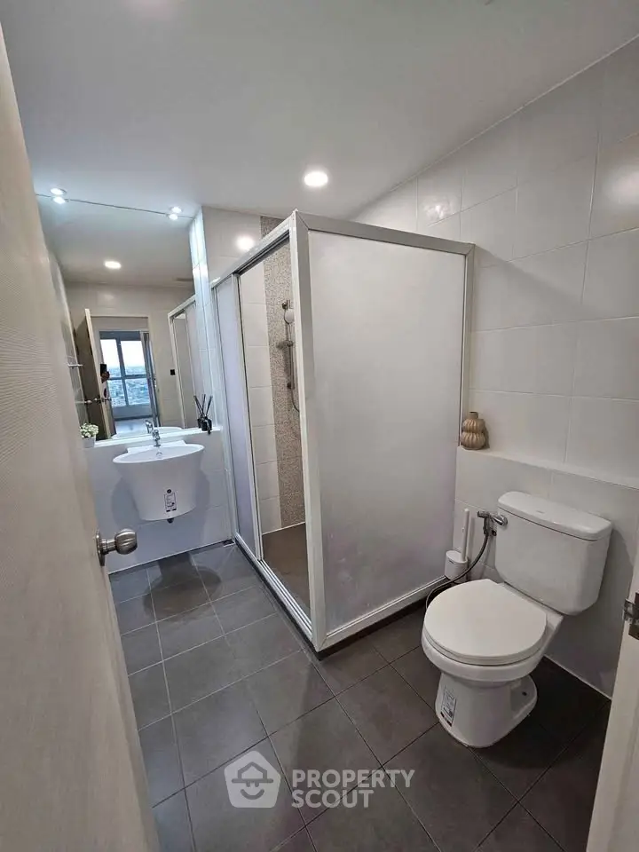 Modern bathroom with shower and sleek fixtures in a contemporary apartment.
