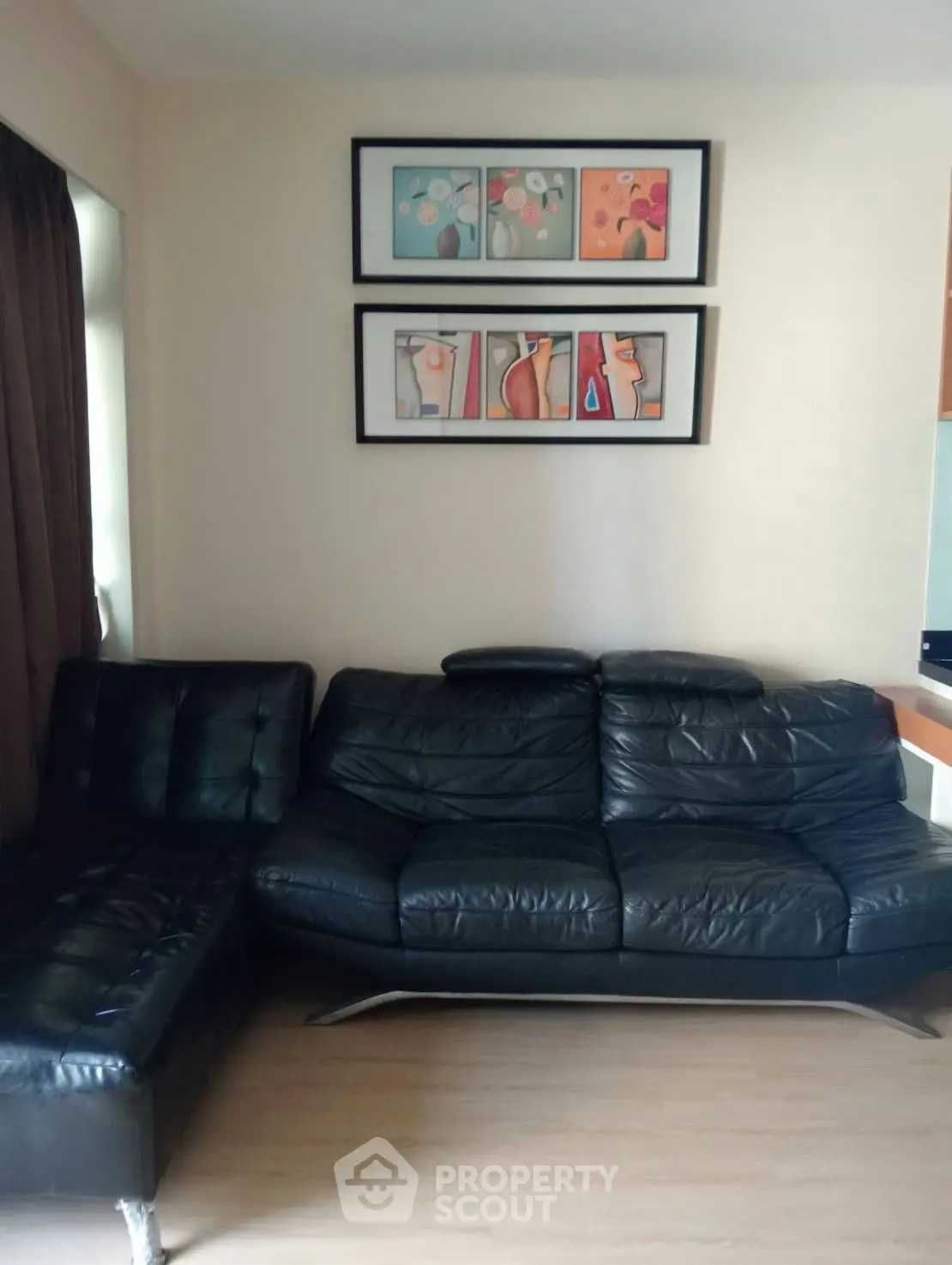 Stylish living room with black leather sofa and modern art decor