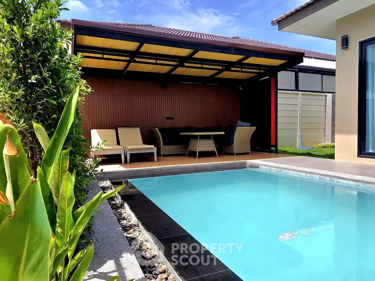 Luxurious backyard with a sparkling pool and stylish outdoor seating area, perfect for relaxation and entertainment.