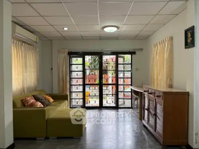 Spacious living room with large windows and modern furniture, perfect for relaxation and entertaining.