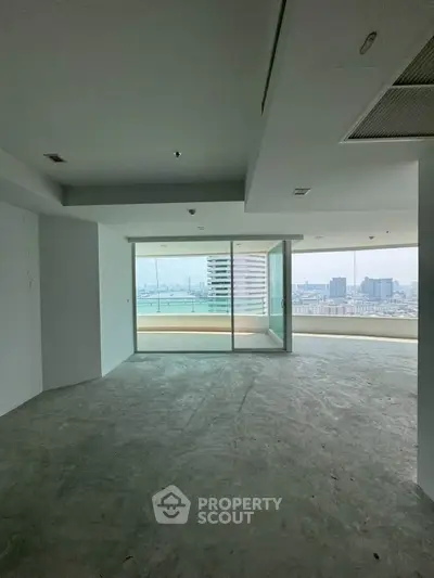 Spacious empty living room with large windows offering stunning cityscape views.