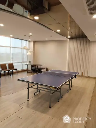 Modern recreation room with ping pong table and stylish lighting