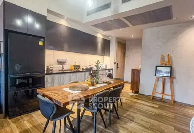 Modern kitchen with sleek design, wooden dining table, and stylish black chairs in a contemporary apartment.