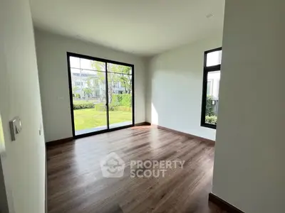Spacious room with large windows and garden view, perfect for natural light lovers.