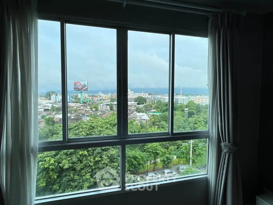 Stunning cityscape view from a modern apartment window, showcasing lush greenery and urban skyline.