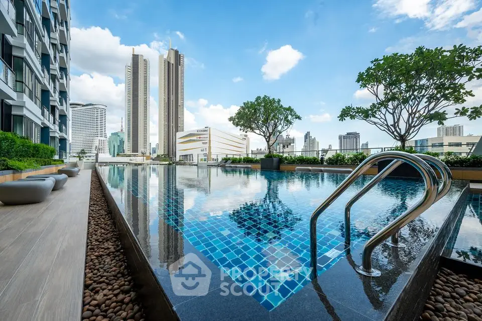 Luxurious rooftop pool with stunning city skyline views in modern high-rise building.
