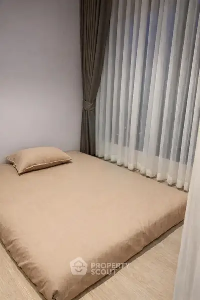 Minimalist bedroom with floor mattress and elegant curtains