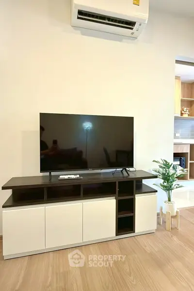 Modern living room with sleek TV stand and air conditioning, perfect for cozy entertainment.