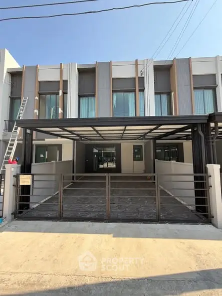 Modern townhouse exterior with spacious driveway and sleek design.