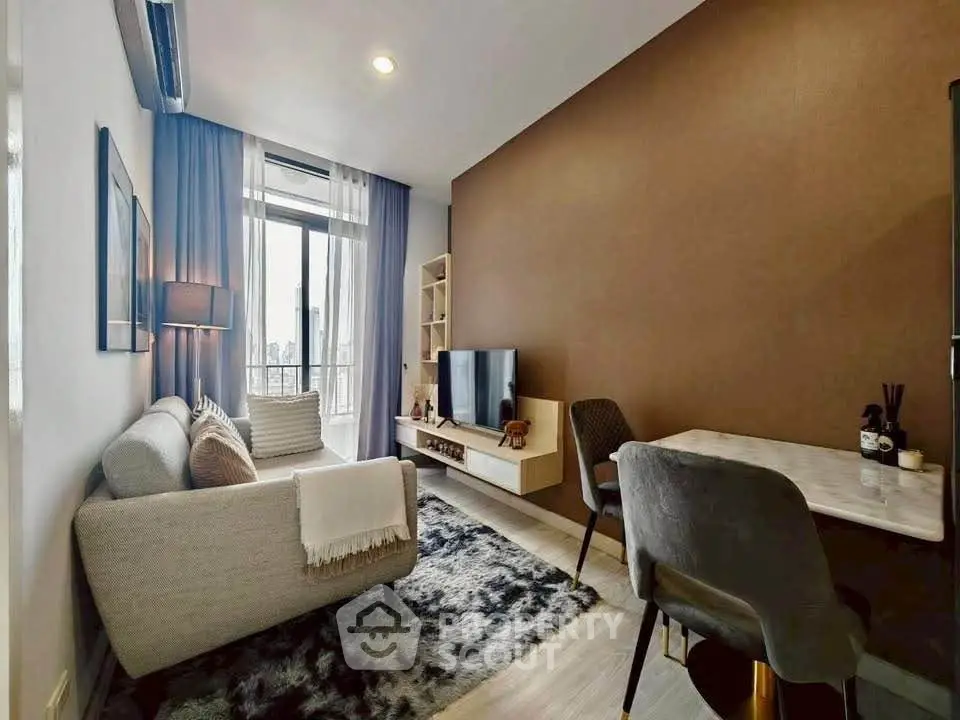 Modern living room with cozy sofa, stylish decor, and natural light from large window.