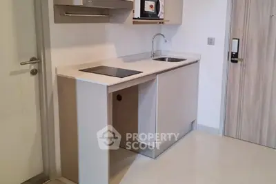 Modern compact kitchen with sleek cabinetry and built-in appliances in a stylish apartment.