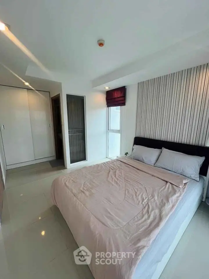 Modern bedroom with sleek design and ample natural light, featuring a comfortable bed and stylish wardrobe.
