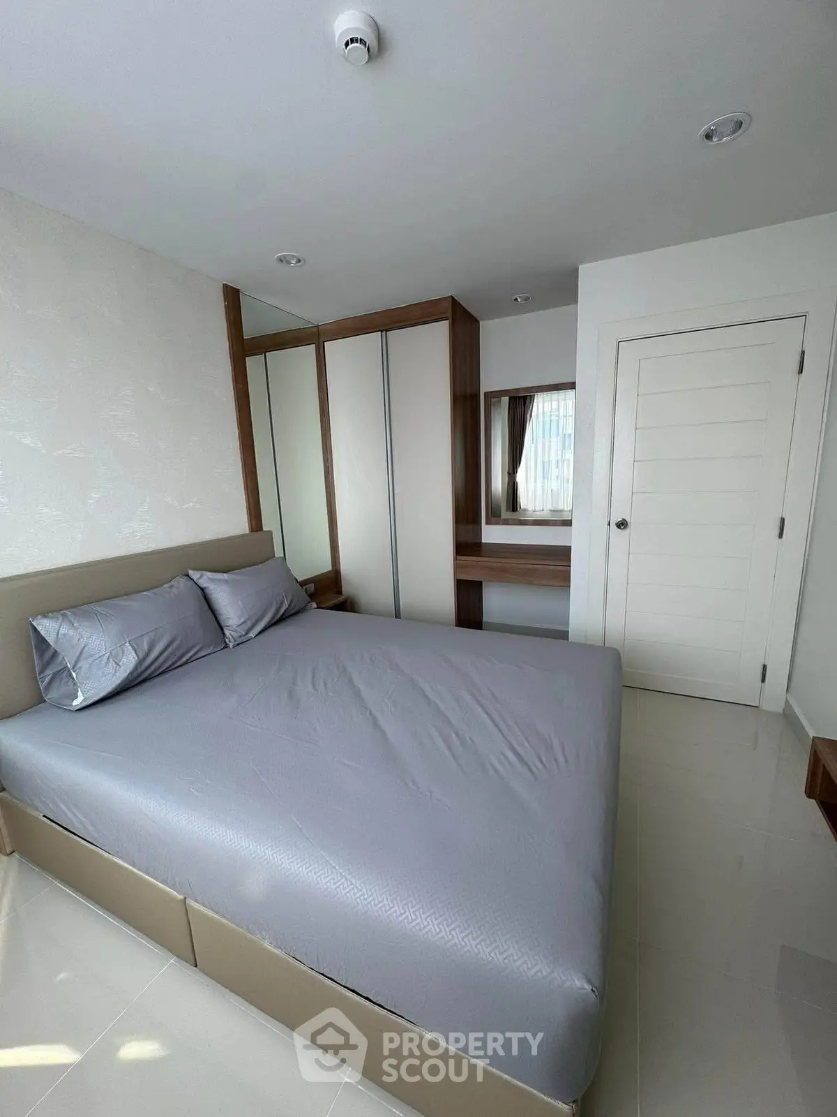 Modern bedroom with sleek design and ample storage in a contemporary apartment.