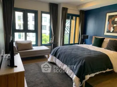 Modern bedroom with large windows and stylish decor in a luxury apartment.