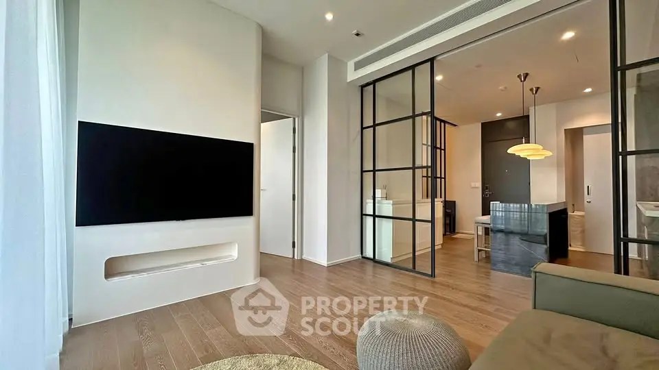 Modern living room with sleek design and large TV, featuring open layout and stylish decor.