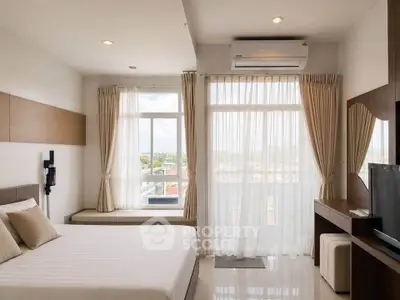 Bright and airy bedroom with large windows and modern furnishings, perfect for relaxation.