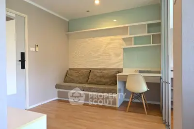 Modern living room with stylish sofa and study desk, featuring elegant wall design and wooden flooring.
