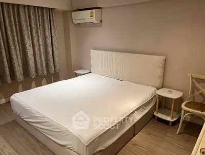 Cozy bedroom with modern decor and air conditioning, perfect for relaxation.