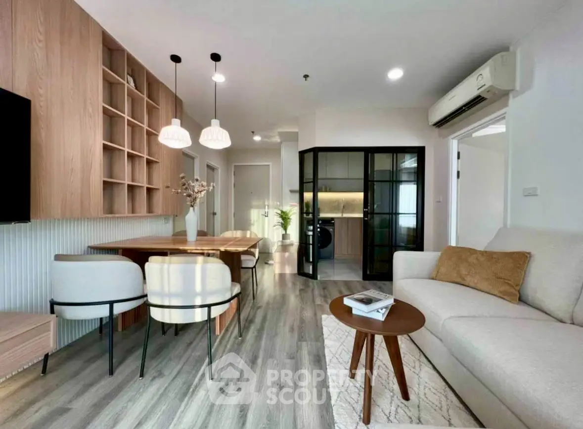 Modern living room with stylish furniture and open layout, featuring a cozy sofa and elegant dining area.