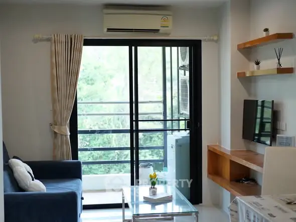 Modern living room with balcony view, featuring sleek furniture and natural light.