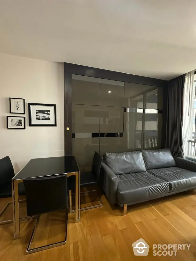 Modern living room with sleek black furniture and hardwood floors