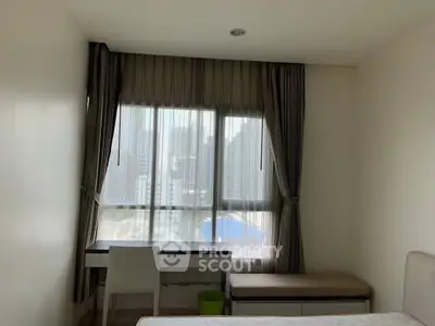 Cozy bedroom with city view and study desk, perfect for urban living.