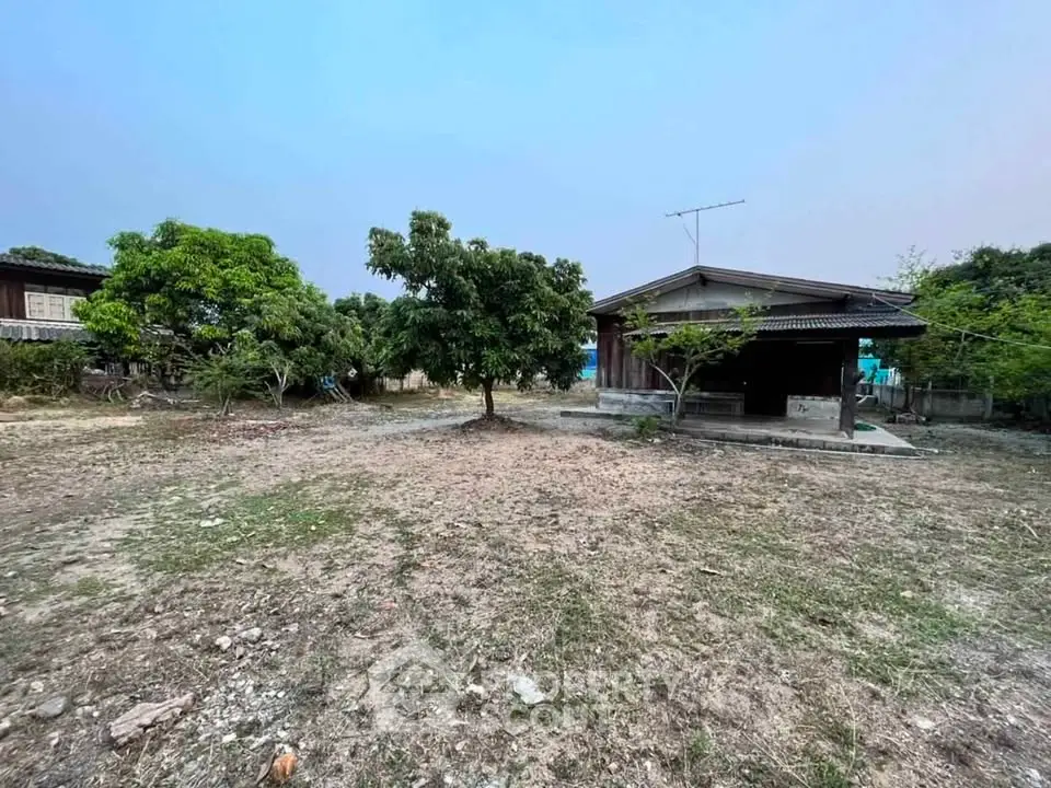 Charming rustic house with spacious yard and lush greenery, perfect for serene living.