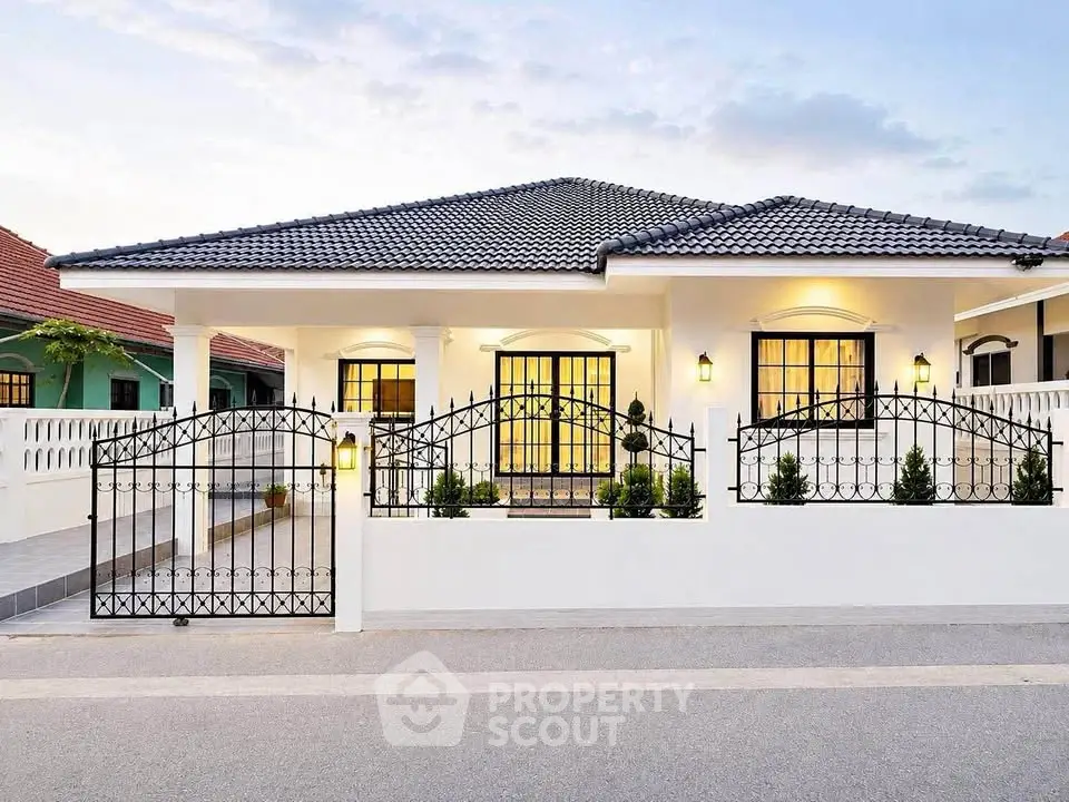 Charming single-story house with elegant iron gate and well-lit facade, perfect for family living.