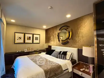 Luxurious bedroom with elegant decor and modern lighting, featuring a stylish mirror and framed art on the wall.