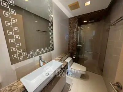 Modern bathroom with elegant fixtures and glass shower enclosure.